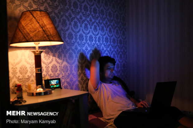 جوانی در حال تماشای فیلم در شرایط قرنطینه خانگی