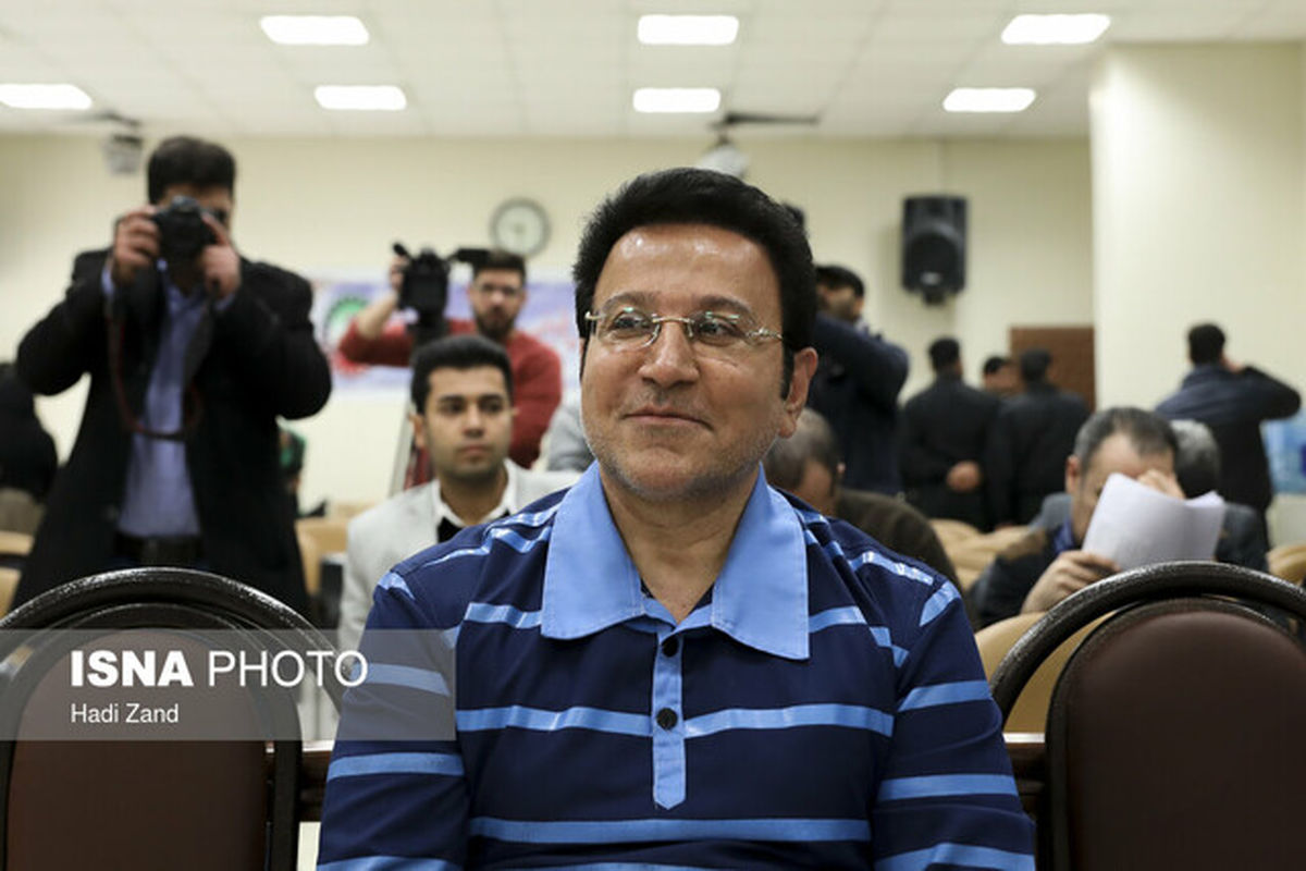 حسین هدایتی با دستبند و ماسک در راهرو دادگاه کیفری تهران